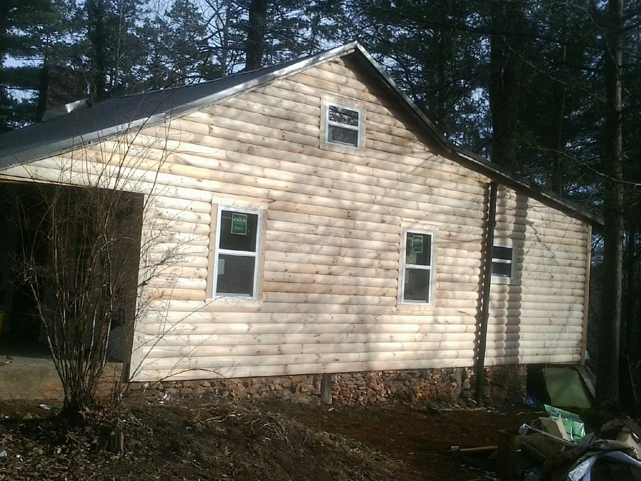 New log siding and dark metal roofing on a gable end in Brentwood
